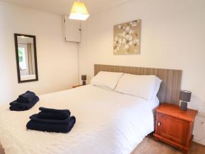 a bedroom with a bed with two black towels on it at Tryfan in Bangor