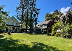 a house with a yard with green grass and trees at Quarrystone House B&B in Fernwood