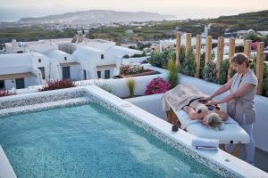 a woman and a child laying in a chair next to a swimming pool at Alleys All-Suite Hotel & Spa in Pirgos