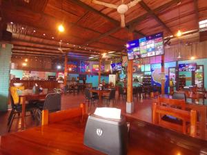 un restaurante con mesas y sillas y un bar en Hotel Aldea Pura Vida en Puntarenas