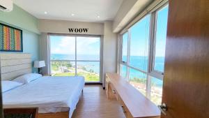 a bedroom with a bed and a view of the ocean at La Mirada Residences in Mactan