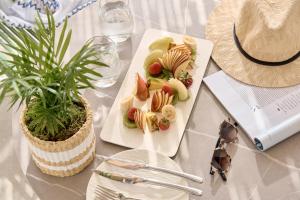 a table with a plate of food and a plant at Alleys All-Suite Hotel & Spa in Pirgos