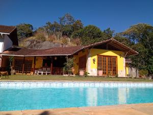 dom z basenem przed nim w obiekcie Pousada Canto da Paz w mieście Petrópolis