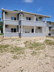 a white house with a yard in front of it at Sunny House Apartments Doni Štoj in Bregvija