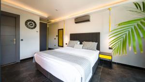 a bedroom with a bed and a clock on the wall at Sea Palm Otel Yalıkavak in Yalıkavak