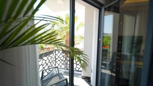 a glass door leading to the balcony of a house at Sea Palm Otel Yalıkavak in Yalıkavak