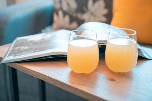 three glasses of orange juice sitting on a table at NOA Luxury Apartment in Bitola