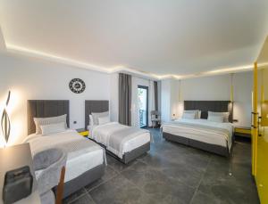 a hotel room with two beds in a room at Sea Palm Otel Yalıkavak in Yalıkavak