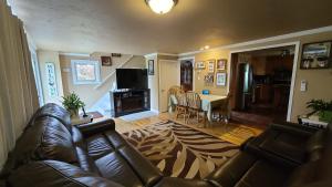 a living room with a leather couch and a table at Small Town Bound Inn in Montague