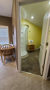 a bathroom with a shower and a table and a chair at Small Town Bound Inn in Montague