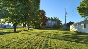 pole trawy z drzewami i dom w obiekcie Small Town Bound Inn w mieście Montague