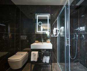 a bathroom with a toilet and a sink and a shower at Sea Palm Otel Yalıkavak in Yalıkavak