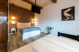 a bedroom with a bed and a brick wall at Loft Sikorskiego in Giżycko