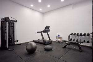 a room with a gym with a treadmill and weights at Alleys All-Suite Hotel & Spa in Pirgos