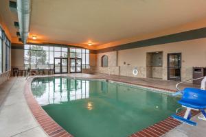 une grande piscine avec une chaise bleue dans un bâtiment dans l'établissement Best Western Premier Pasco Inn and Suites, à Pasco