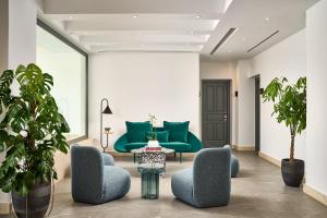 a living room with a green couch and chairs at Alleys All-Suite Hotel & Spa in Pirgos