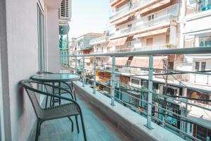 un balcone con tavolo e sedia su un edificio di Lovely apartment with balcony in the city center a Kateríni