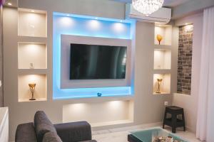 sala de estar con TV de pantalla plana en la pared en Lovely apartment with balcony in the city center, en Katerini