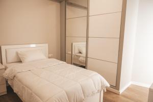 una camera con letto bianco e specchio di Lovely apartment with balcony in the city center a Kateríni
