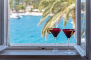 two wine glasses sitting on a window sill at Apartman Rosana in Hvar