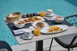 a table with plates of food and drinks on it at Alleys All-Suite Hotel & Spa in Pirgos