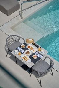 a table with food on it next to a swimming pool at Alleys All-Suite Hotel & Spa in Pirgos