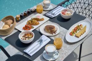 a table topped with plates of food and drinks at Alleys All-Suite Hotel & Spa in Pirgos
