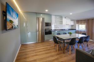 a kitchen and dining room with a table and chairs at Modern Apartment With Garden in Fátima