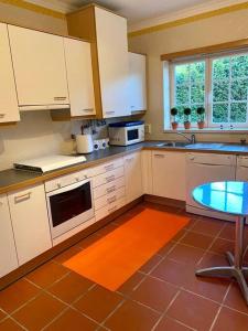 uma cozinha com armários brancos e um piso laranja em Golf & Praia Del Rey - Óbidos -6 hospedes em Óbidos
