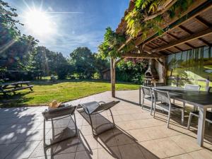 un patio con mesa, sillas y mesa de picnic en Gîte Froidfond, 5 pièces, 8 personnes - FR-1-426-149, en Froidfond