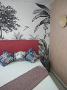 - une chambre dotée d'un lit avec une tête de lit rouge et du papier peint en palmier dans l'établissement GoToSeville ALTAIR SUITES, à Séville