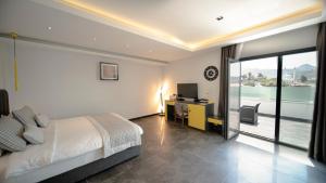 a bedroom with a bed and a desk with a television at Sea Palm Otel Yalıkavak in Yalıkavak