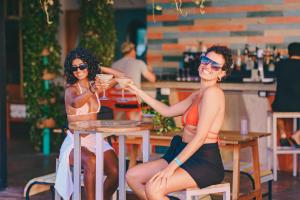 two women sitting at a table with drinks at Mayan Monkey Hotel & Hostel Cancun in Cancún