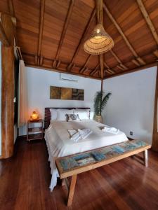 a bedroom with a large bed and a wooden ceiling at Villa Bulan in Arraial d'Ajuda