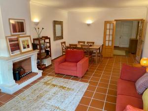 a living room with a red couch and a fireplace at Golf & Praia Del Rey - Óbidos -6 hospedes in Óbidos