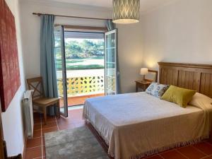 Golf & Praia Del Rey - Óbidos -6 hospedes في أوبيدوس: غرفة نوم بسرير وباب بلكونه