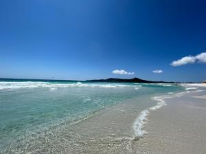 a beach with the ocean and a blue sky at Éolos Loft's - Cabo Frio in Cabo Frio