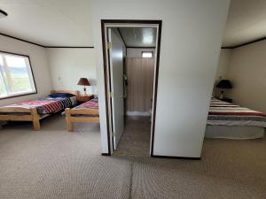 Habitación con 2 camas y puerta que conduce a un dormitorio. en Eagles Landing Campground en Sturgis