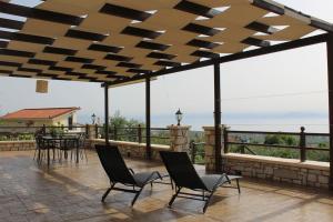 a patio with chairs and tables and a view of the ocean at Ένα σπίτι γεμάτο φύση! - A house full of nature! in Longá