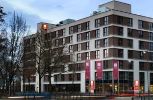a building with a red traffic light in front of it at Leonardo Hotel Offenbach Frankfurt in Offenbach