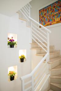 a white staircase with potted plants on the wall at Hotel Casa Alom in Cali