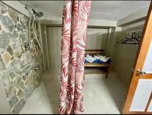 a bathroom with a shower with red and white stripes at Castara Inn in Castara
