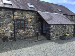 a stone building with a door and a window at Hendre in Llanllyfni