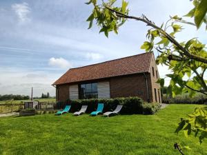 a group of chairs sitting in the grass in front of a house at Gîte Nieppe, 5 pièces, 8 personnes - FR-1-510-4 in Nieppe