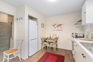 a kitchen with a table and a white refrigerator at Mountain View Bliss - Albert Town Holiday Unit in Albert Town