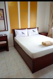 a bed with a wooden headboard in a room at Bukit Merah 99 Motel(Suria Apartment) in Kampong Selemat