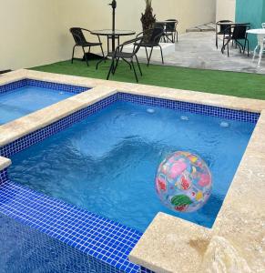 una piscina con una pelota de playa en el agua en A-1 Hermoso Apartamento tipo villa al pie de la montaña elitevillasjarabacoa, en Jarabacoa