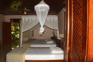 a bedroom with two beds and a chandelier at Sea World Club Beach Resort & Dive Center in Maumere