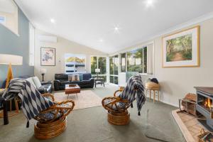 a living room with chairs and a fireplace at 24 Hyam Rd Hyams Beach in Hyams Beach