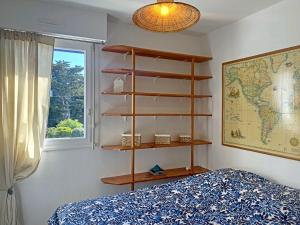 a bedroom with a book shelf next to a bed at Ploemeur Lomener T2 Balcon Vue Mer - FR-1-349-65 in Ploemeur